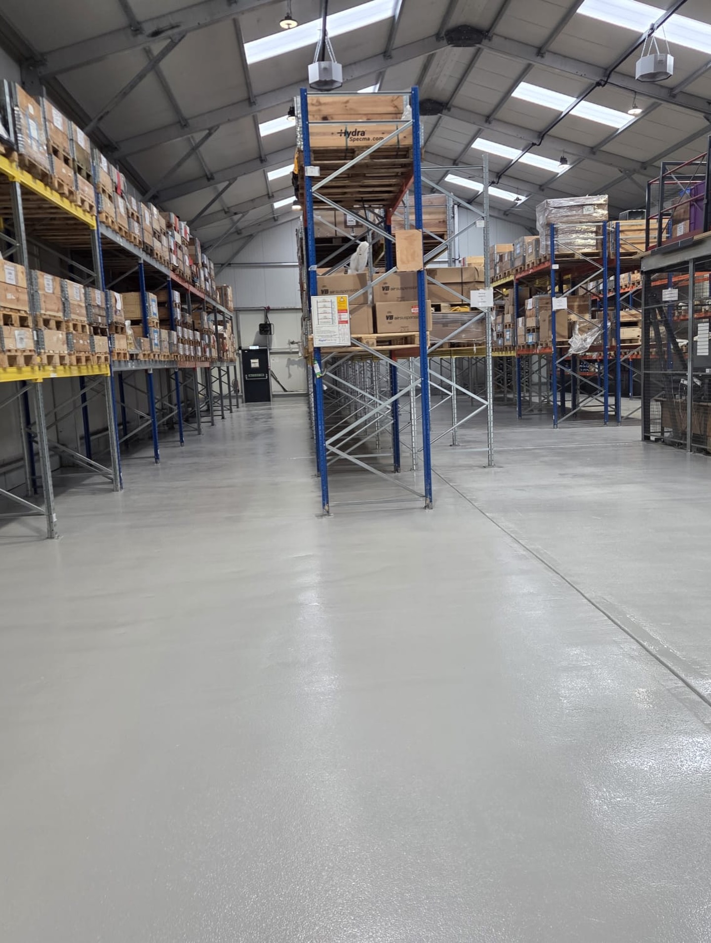 Seamless grey resin floor in a warehouse store with pallet racking