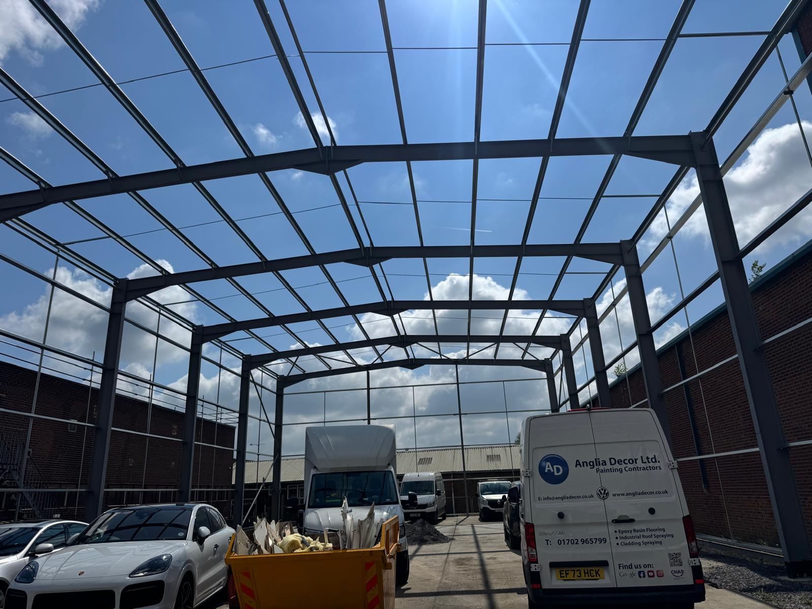 Steel portal frame of an industrial unit under construction with the Anglia Decor van on site