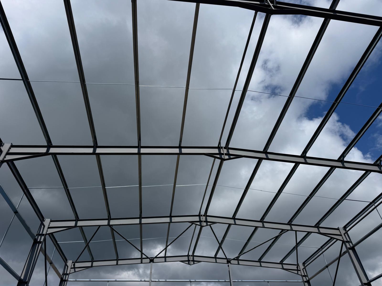 Steel portal frame of a new industrial building under construction against the sky
