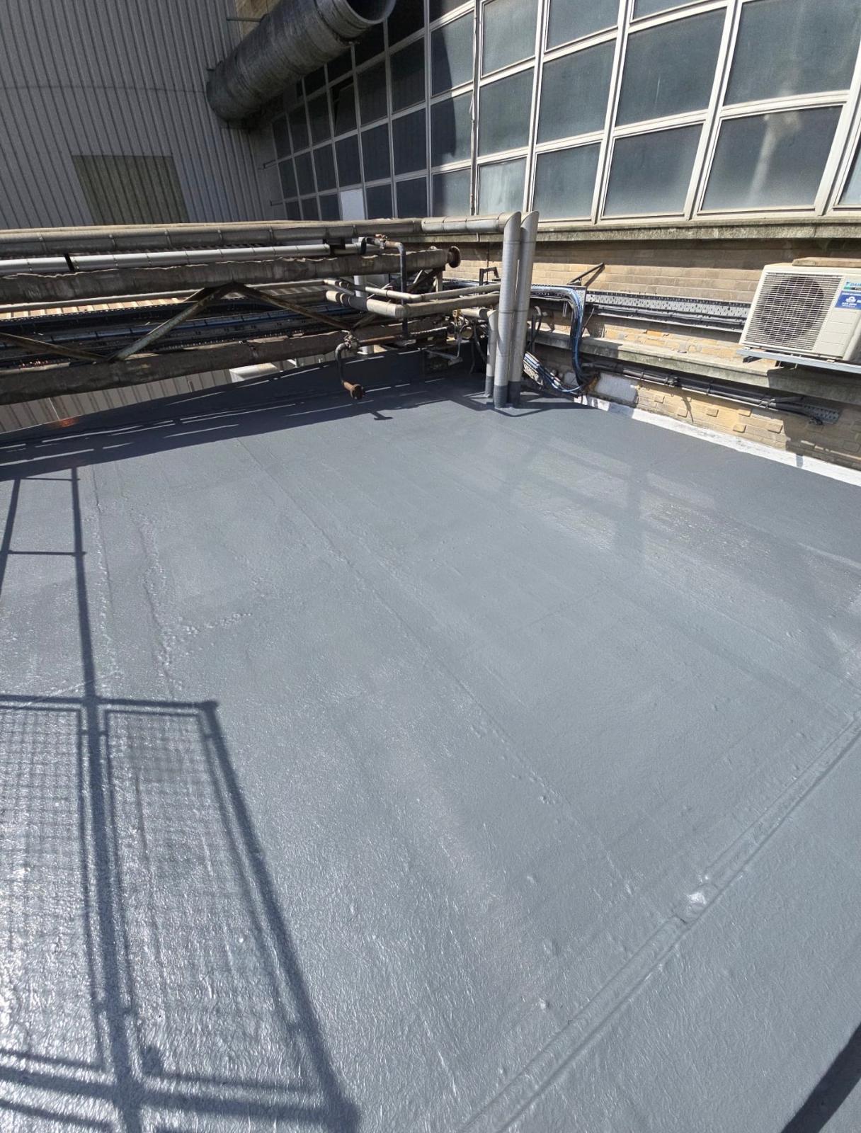 Liquid-applied roof coating on industrial plant rooftop
